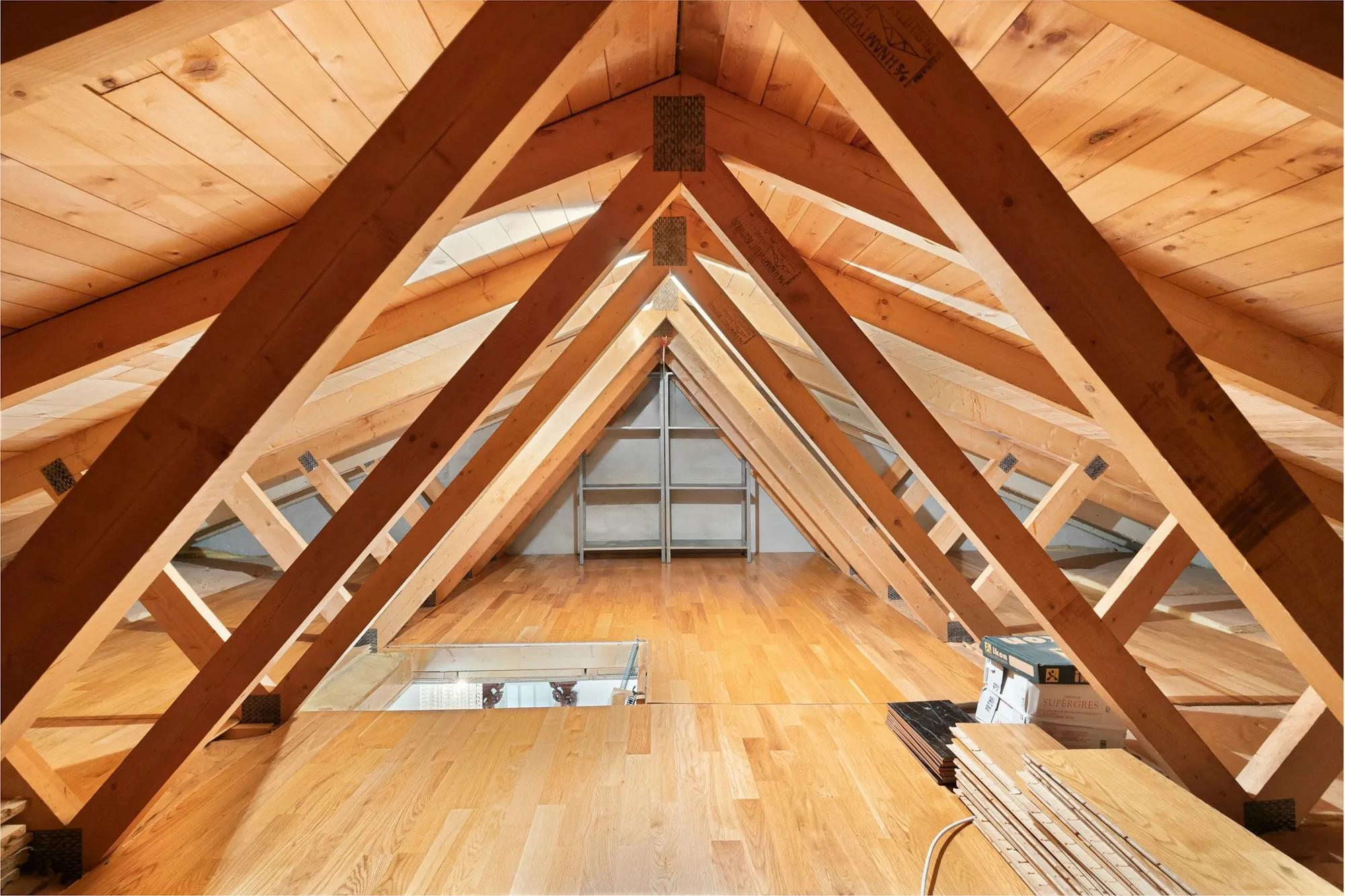 Bright attic with exposed wood trusses and a pine ceiling, the kind of space checked during a roof insurance adjuster inspection in Berkeley Lake