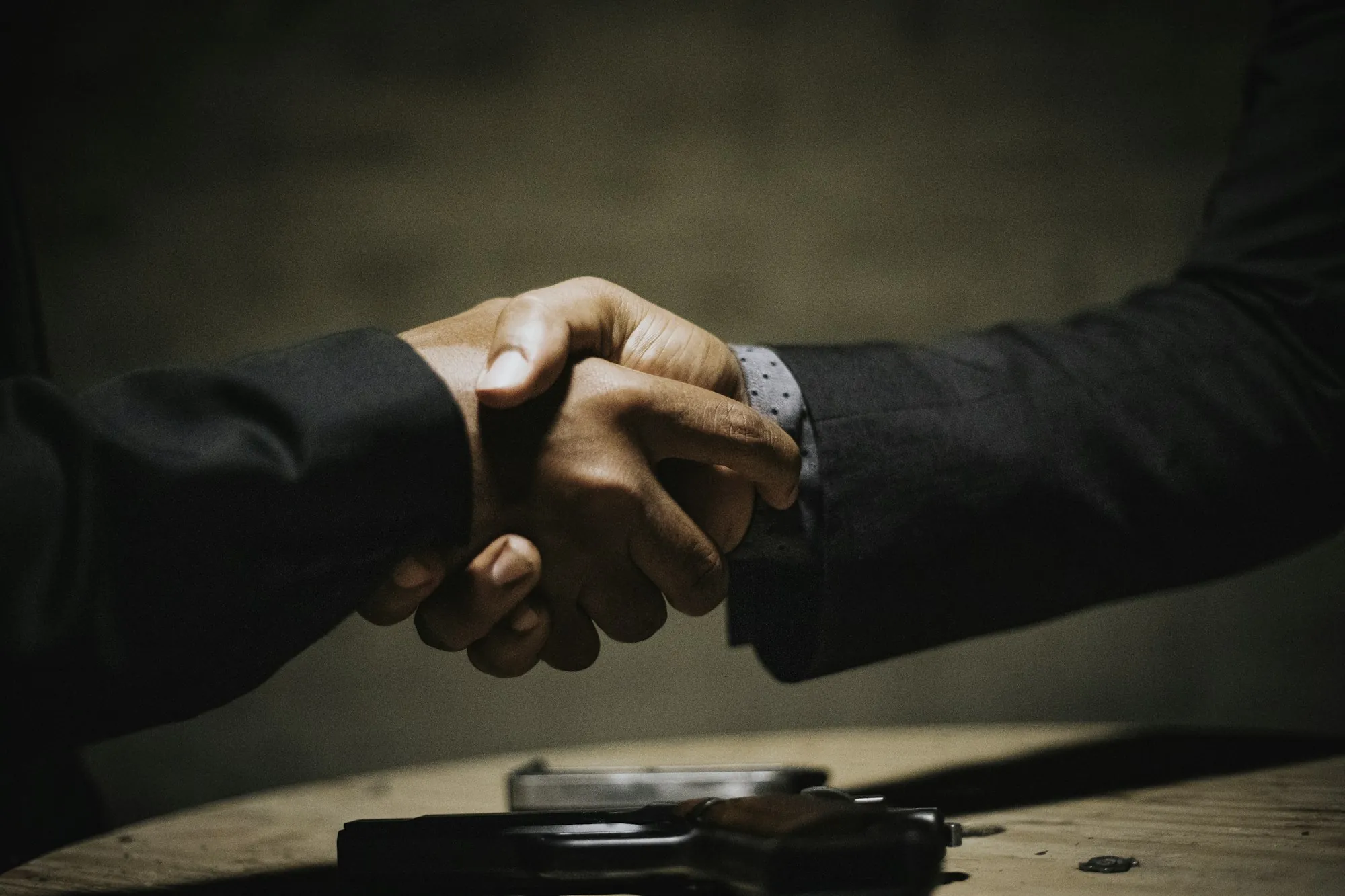 Handshake over a table in warm dramatic light